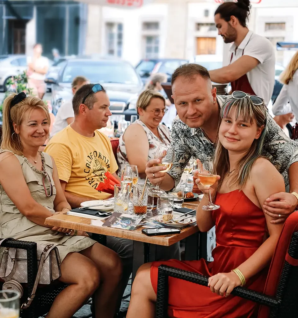 Guests with glasses in hand on the garden of the Awiw restaurant